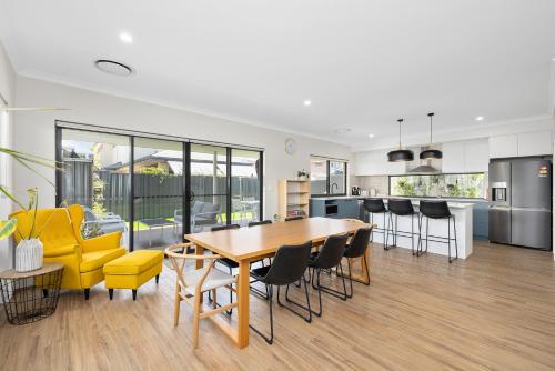 a kitchen and dining room with a table and chairs at Family Friendly Close 2 Airport, Optus, Crown & City in Perth