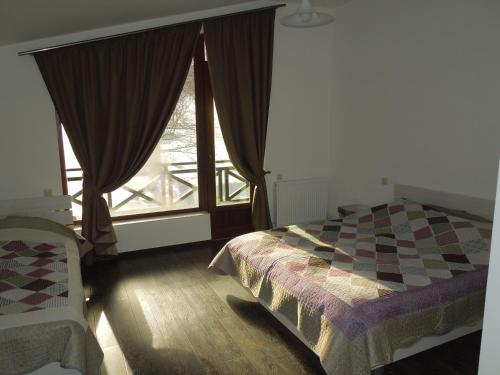 a bedroom with a bed and a large window at Villa Didveli Bakuriani in Bakuriani