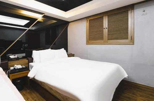 a bedroom with a large white bed and a window at Zenith Hotel in Guri