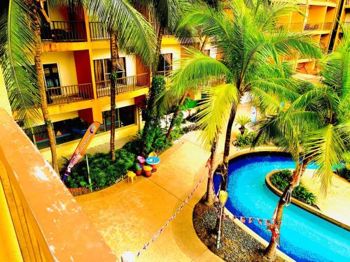 Una vista aérea de un complejo turístico con piscina y palmeras. en Gold Coast Morib Theme Park View Unit, en Banting