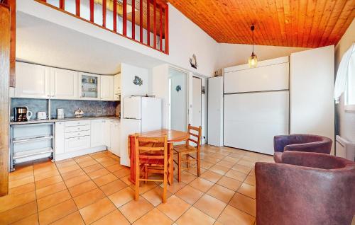 ヴォー・シュル・メールにある1 Bedroom Stunning Home In Vaux-Sur-Merのテーブルと椅子と冷蔵庫のあるキッチン