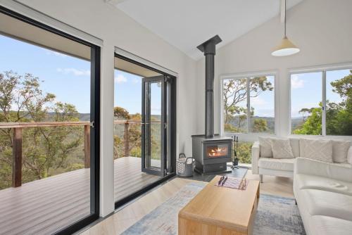 Una sala de estar con un sofá y una chimenea. en Blue Mountain Views, en Wentworth Falls