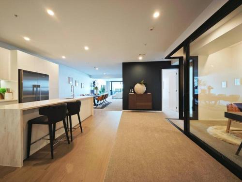 a kitchen and living room with a counter and chairs at Hereford aparment in Auckland