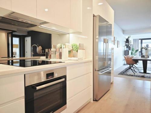 a large kitchen with a stove top oven and a table at Hereford aparment in Auckland