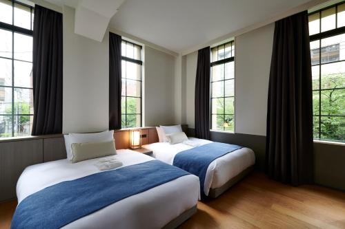 京都市にあるTHE GATE HOTEL京都高瀬川 by HULICの窓付きのホテルの部屋にベッドが2つある