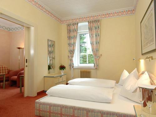 una camera d'albergo con letto e finestra di Seevilla Wienerroither a Pörtschach am Wörthersee