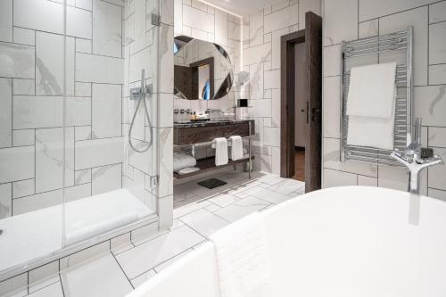 a bathroom with a shower and a sink at Stock Exchange Hotel, Manchester, Autograph Collection in Manchester