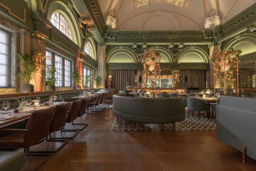 a restaurant with tables and chairs in a building at Stock Exchange Hotel, Manchester, Autograph Collection in Manchester