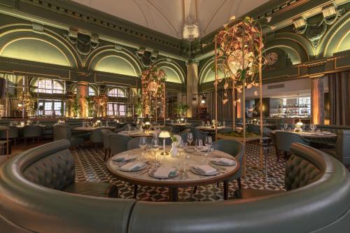 a dining room with tables and chairs and ceilings at Stock Exchange Hotel, Manchester, Autograph Collection in Manchester