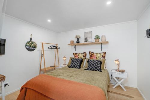 une chambre avec un lit avec des oreillers dessus dans l'établissement Hosts on the Coast Bayview Sanctuary, à Whitianga