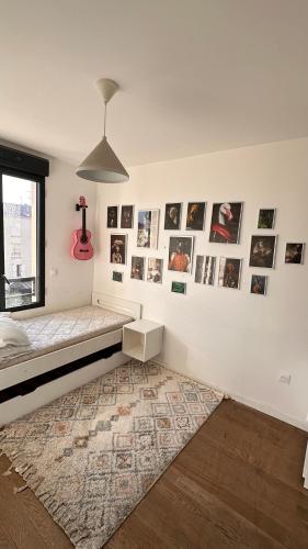 une chambre avec un lit et des tableaux au mur dans l'établissement Central, à Colombes