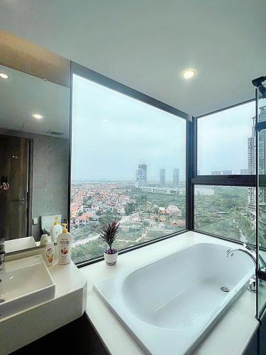 a bathroom with a bath tub and a large window at Homestay Onsen Ecopack in HÆ°ng YÃªn