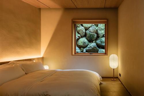 a bedroom with a bed and a painting on the wall at 大山初里 Origin Villa Village Hotel&Resort in Tonglu