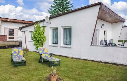 a yard with two chairs and a house at Ferienhaus Plau Am See in Kummerow