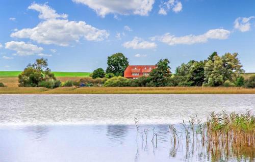 un grande lago con un fienile rosso sullo sfondo di Ferienwohnung Hohen Wangelin a Hohen Wangelin