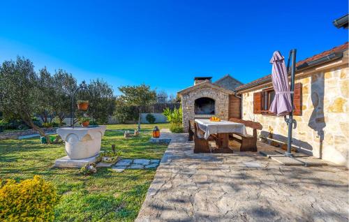 a patio with a table and an umbrella in a yard at One-Bedroom Holiday Home In Konjevrate in Konjevrate