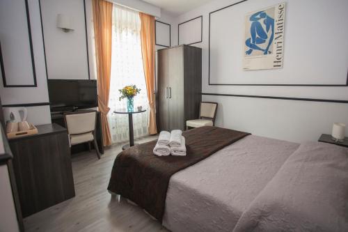 Un dormitorio con una cama y una mesa con zapatos. en Royal Suite du Vatican, en Roma