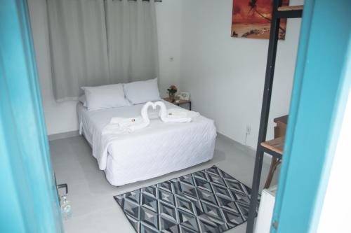 a bedroom with a bed with two white shoes on it at Hotel Praia do Morro in Guarapari