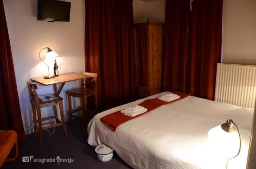 a hotel room with a bed and a desk at HCR Teernstra in Balk
