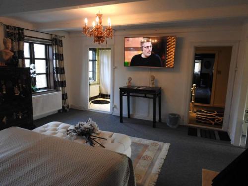 a bedroom with a bed and a tv on the wall at Queen suite in a hotel in Tranekær in Tranekær