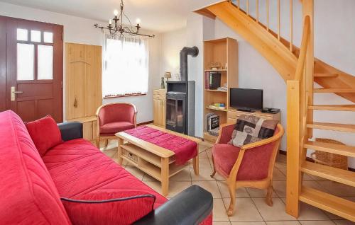 sala de estar con sofá rojo y escalera en Ferienhaus Thomsdorf, en Thomsdorf