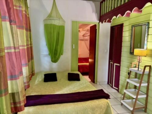 una camera con letto, scala e lampada di Bungalow confortable à Sainte-Anne, 45 m² avec jardin a Sainte-Anne