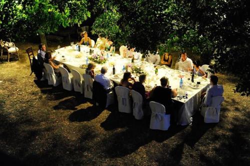 a group of people sitting at a long table at Villa Palazzo Bello con piscina e AC - Cetona in Cetona