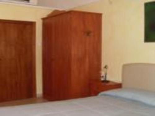 a bedroom with a bed and a wooden cabinet at B&B Frammenti D'Itria in Ceglie Messapica