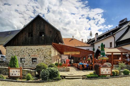 a building with people sitting at tables in front of it at Hotel U Martina in Rožmberk nad Vltavou