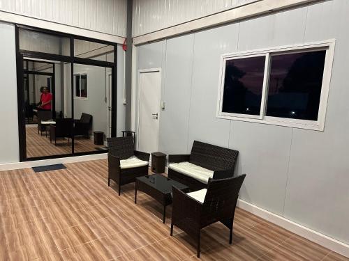 a room with chairs and a table and windows at U Cube Staycation in Manaoag
