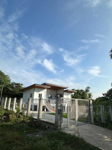 a white house with a gate and a fence at U Cube Staycation in Manaoag