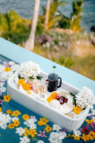 a tray of food on a table with flowers at Bintana Sa Paraiso in Mambajao