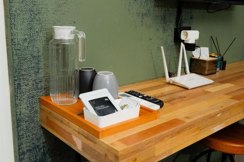 a table with a glass bottle on a wooden table at Lyn Urban by Atmosfera in Jepara