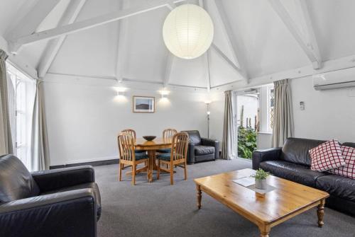 a living room with couches and a table at Camelot Motor Lodge in Christchurch