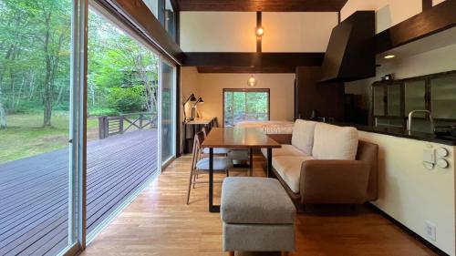 a kitchen and living room with a table and a dining room at HANOOTO Kitakarauizawa in Tsumagoi