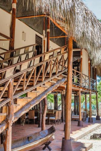 a staircase to a resort with a straw roof at Castillete Hotel & Beach Club in Tierra Bomba