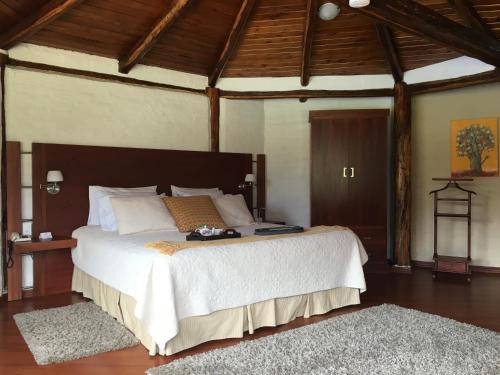 a bedroom with a large bed in a room with wooden ceilings at Casa d'Campo Tababela Hotel Boutique in Tababela