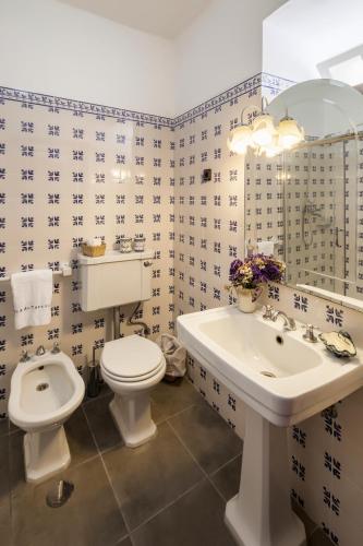 a bathroom with a white toilet and a sink at Quinta de Marrocos in Peso da Régua