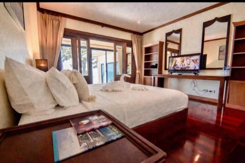 a bedroom with a large bed and a table with aaptop at The best view of coastal 02 in Ban Ao Kung