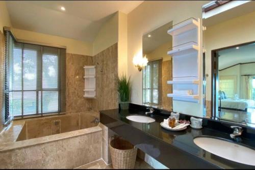 a bathroom with two sinks and a large mirror at The best view of coastal 02 in Ban Ao Kung