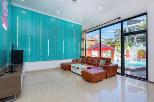 a living room with a couch and a tv at Sun Villa 168 - 7 Phòng Ngủ - Gần Biển Bãi Sau in Vung Tau