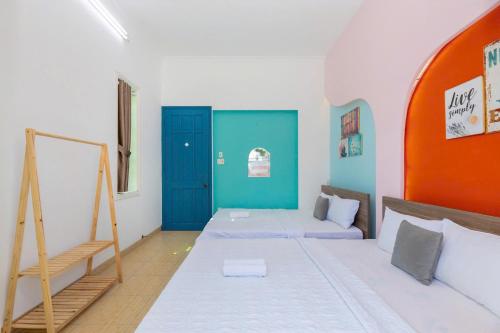a room with two beds and an orange and blue door at Sun Villa 168 - 7 Phòng Ngủ - Gần Biển Bãi Sau in Vung Tau