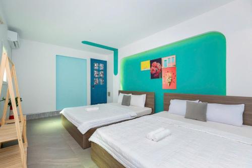 two beds in a room with a green wall at Sun Villa 168 - 7 Phòng Ngủ - Gần Biển Bãi Sau in Vung Tau