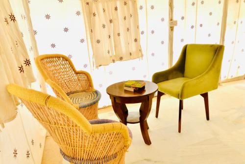 a living room with two chairs and a table at DESERT OVERNIGHT LUXURY CAMP & ReSORT in Jaisalmer