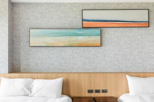 a painting hangs above a bed in a hotel room at Jhai Wu in Kenting