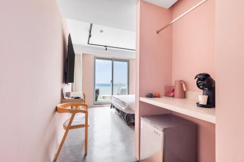 a bedroom with a bed and a desk with a chair at Jhai Wu in Kenting