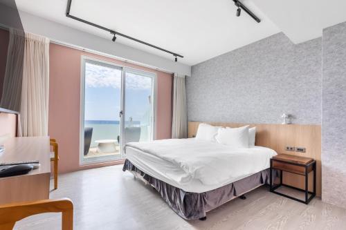a bedroom with a large bed and a large window at Jhai Wu in Kenting