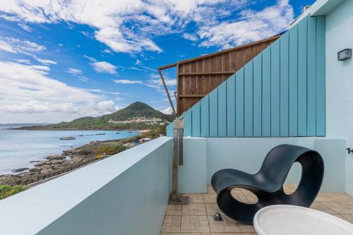 a chair sitting on a balcony overlooking the ocean at Jhai Wu in Kenting