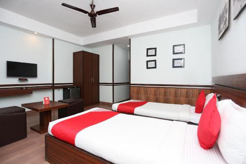 a bedroom with two beds and a flat screen tv at Hotel O The Stay in Kolkata