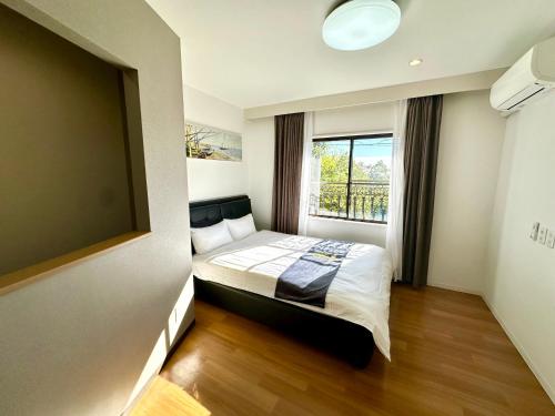 a bedroom with a bed and a large window at 伊東山荘-Toki- in Ito
